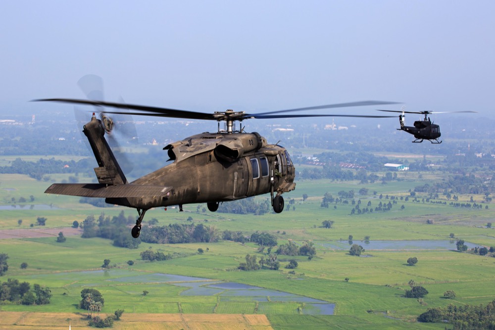Utility helicopters flying low over farmland